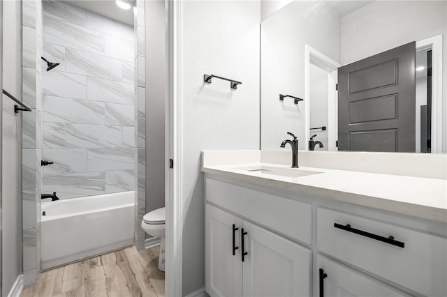 bathroom featuring shower / washtub combination, vanity, toilet, and wood finished floors