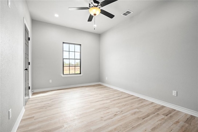 unfurnished room with a ceiling fan, light wood-type flooring, visible vents, and baseboards