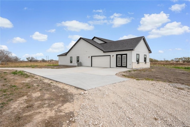 view of side of home with a garage, concrete driveway, and board and batten siding