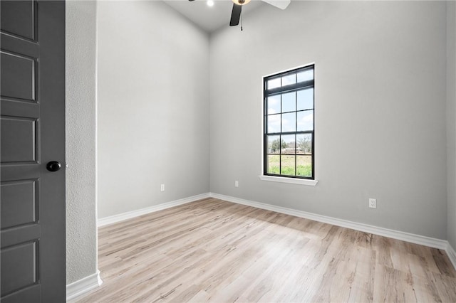 empty room featuring light wood finished floors, ceiling fan, and baseboards