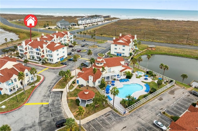 birds eye view of property with a water view and a view of the beach