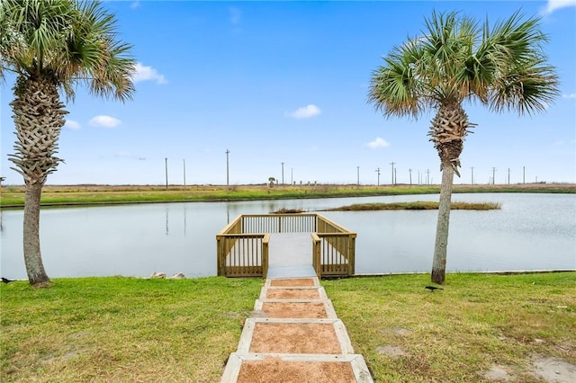 dock area with a water view and a yard