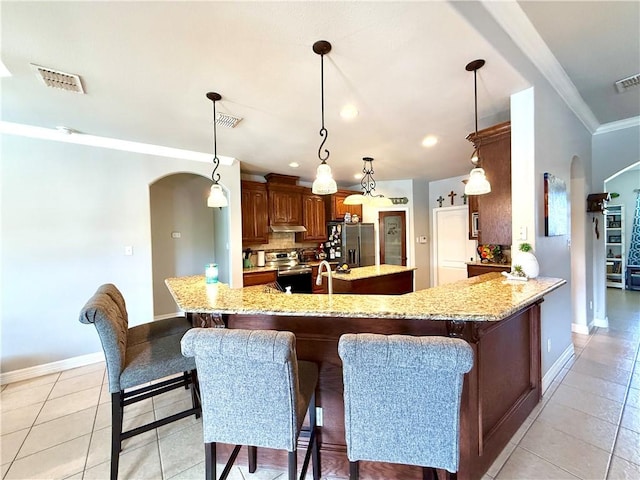 6717 Battery Park Ct, Corpus Christi, TX 78414 - kitchen featuring arched walkways, stainless steel appliances, light tile patterned floors, crown molding, and recessed lighting