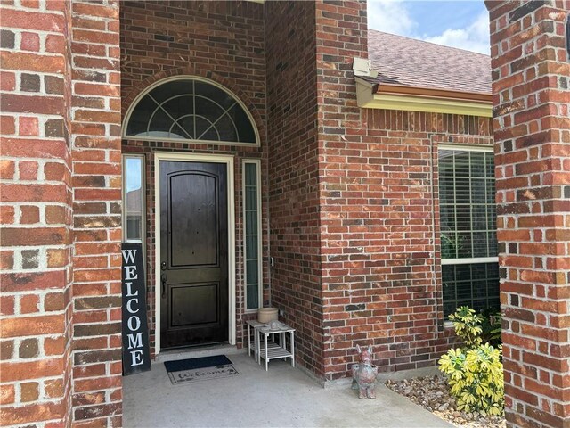 6717 Battery Park Ct, Corpus Christi, TX 78414 - view of exterior entry featuring brick siding and roof with shingles