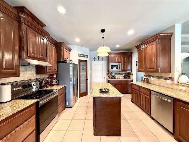 6717 Battery Park Ct, Corpus Christi, TX 78414 - kitchen with stainless steel appliances, under cabinet range hood, decorative backsplash, a center island, and pendant lighting