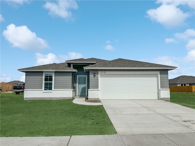 view of front of home with a front yard and a garage