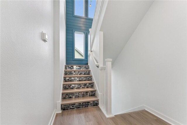 staircase with baseboards and wood finished floors