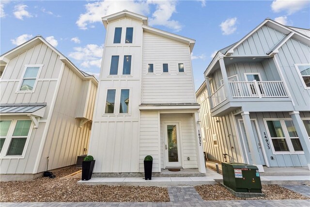 view of front facade with board and batten siding and a balcony