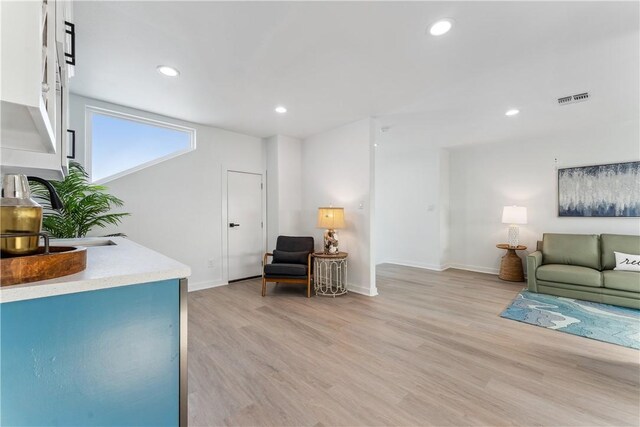 living room featuring visible vents, recessed lighting, baseboards, and light wood-type flooring