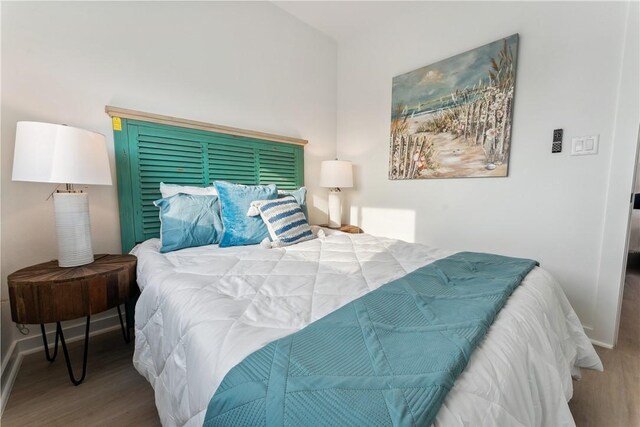 bedroom featuring baseboards and wood finished floors