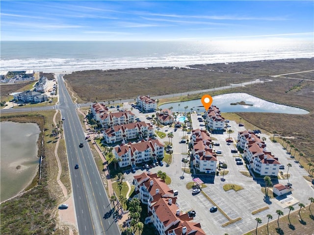 drone / aerial view with a water view and a beach view