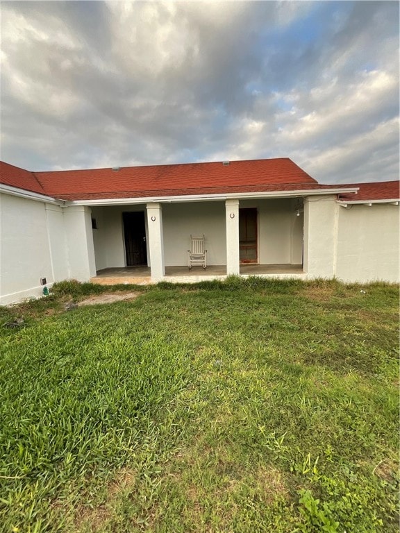 rear view of house with a lawn and a patio