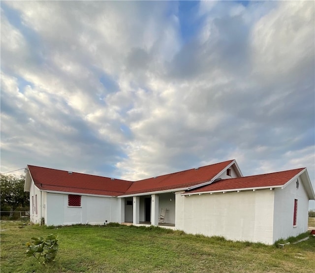 rear view of property with a lawn