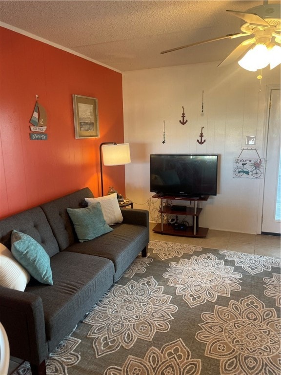 living room featuring a textured ceiling, ceiling fan, and crown molding