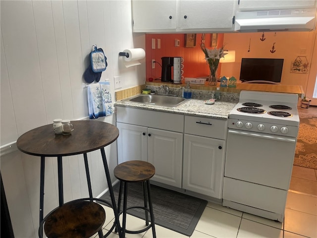 kitchen with light tile patterned floors, exhaust hood, white range, sink, and white cabinets