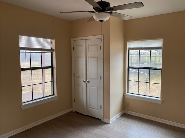 unfurnished bedroom featuring ceiling fan, a closet, and light hardwood / wood-style flooring