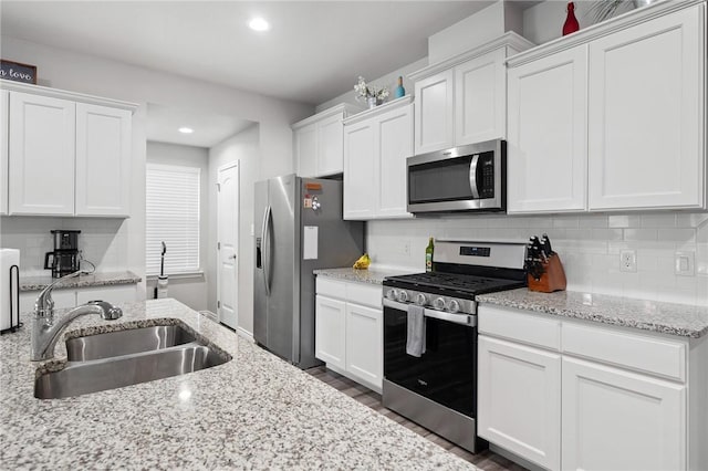 7218 Tristan, Corpus Christi, TX 78414 - kitchen with appliances with stainless steel finishes, a sink, white cabinetry, recessed lighting, and decorative backsplash