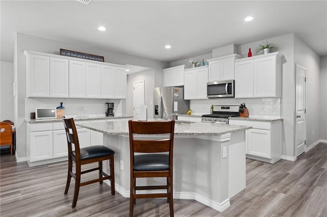 7218 Tristan, Corpus Christi, TX 78414 - kitchen featuring appliances with stainless steel finishes, light wood-style floors, a center island with sink, and recessed lighting