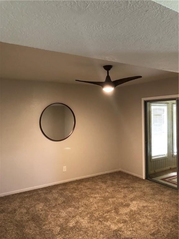 spare room featuring a textured ceiling, ceiling fan, and carpet flooring