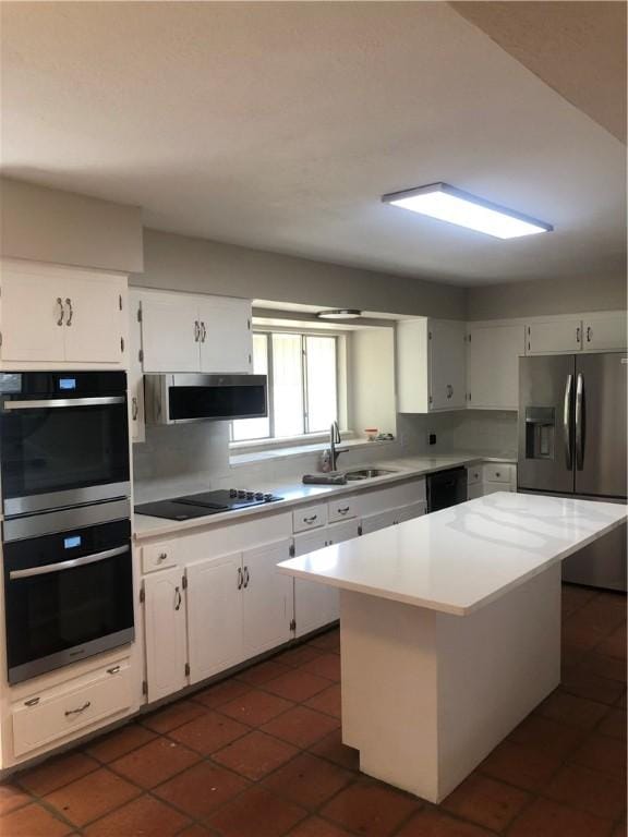 kitchen featuring white cabinetry, sink, black appliances, and a kitchen island