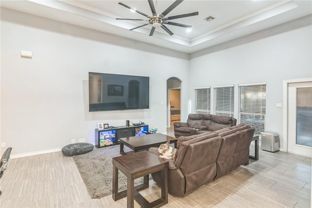 6705 Empire State Dr, Corpus Christi, TX 78414 - living room featuring ceiling fan, arched walkways, light wood-style flooring, a high ceiling, and a raised ceiling