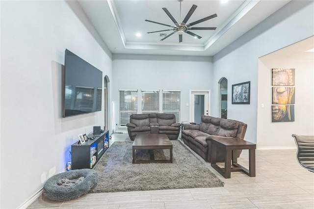 6705 Empire State Dr, Corpus Christi, TX 78414 - living room featuring arched walkways, a ceiling fan, a towering ceiling, a raised ceiling, and crown molding