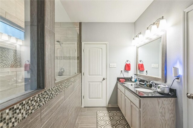 6705 Empire State Dr, Corpus Christi, TX 78414 - bathroom featuring double vanity, a tile shower, and tile walls
