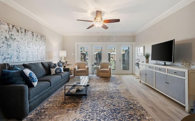 living room with light wood-style flooring, a ceiling fan, and crown molding