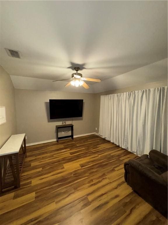 living room with ceiling fan, vaulted ceiling, and dark hardwood / wood-style flooring