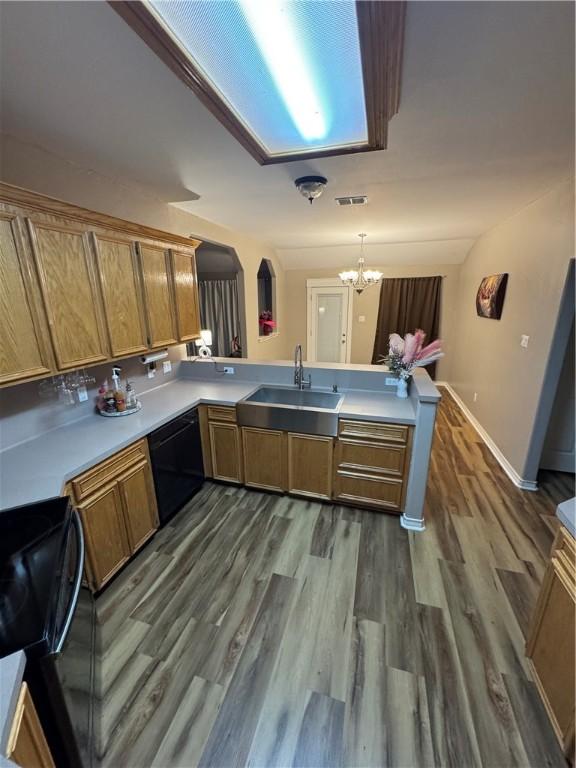 kitchen with kitchen peninsula, stove, black dishwasher, sink, and pendant lighting