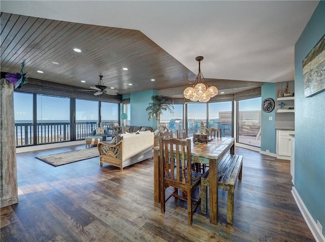 dining space featuring dark hardwood / wood-style flooring, wood ceiling, plenty of natural light, and a water view