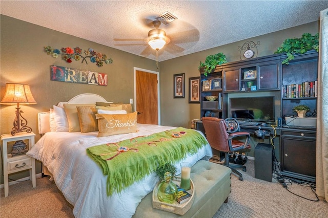 carpeted bedroom with a textured ceiling and ceiling fan