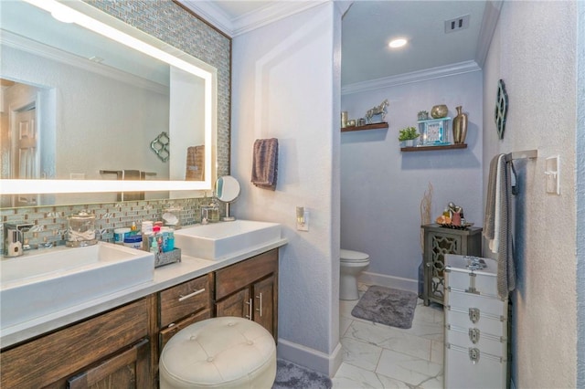 bathroom featuring backsplash, crown molding, vanity, and toilet