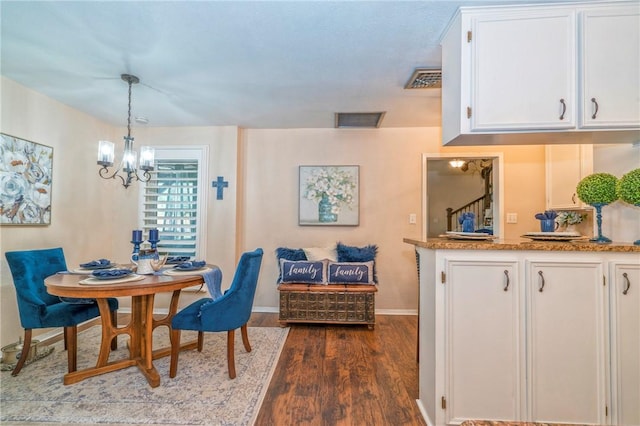 dining area featuring a notable chandelier and dark wood-type flooring