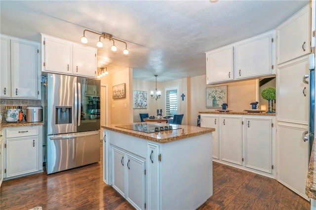 kitchen with pendant lighting, white cabinetry, stainless steel refrigerator with ice dispenser, and black electric cooktop