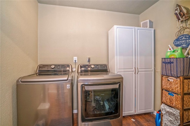 clothes washing area with dark hardwood / wood-style floors, cabinets, and washing machine and dryer