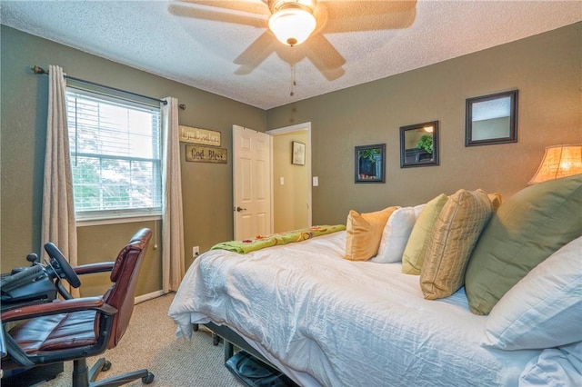 carpeted bedroom featuring ceiling fan and a textured ceiling