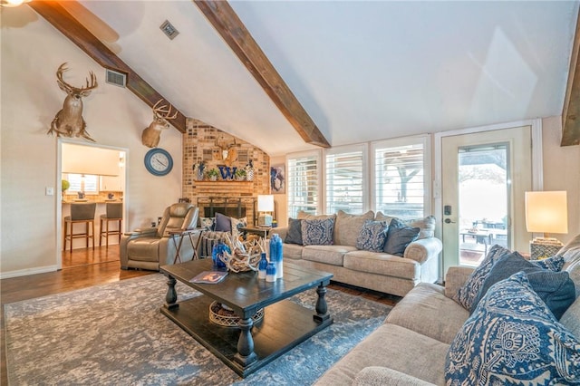 living room featuring lofted ceiling with beams, a fireplace, and wood-type flooring