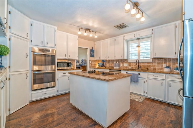 kitchen featuring a kitchen island, white cabinetry, stainless steel appliances, and stone counters