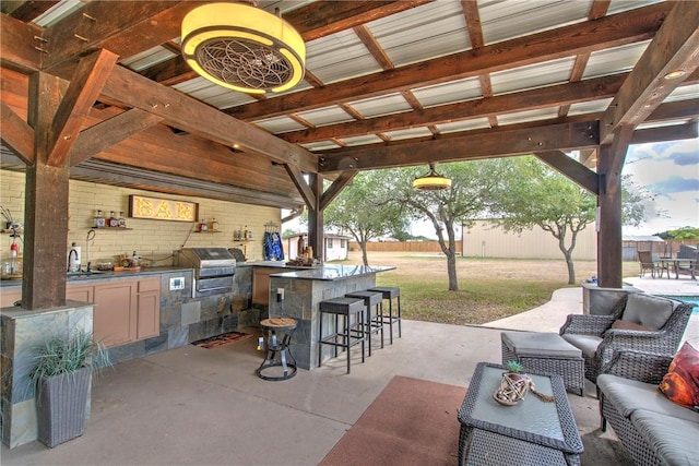 view of patio / terrace featuring grilling area, area for grilling, a bar, and an outdoor hangout area