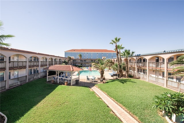 view of yard with a community pool, a balcony, and a gazebo