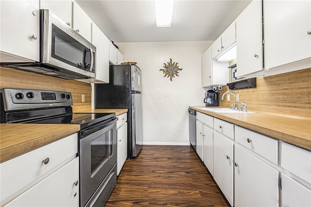 kitchen with stainless steel appliances, dark hardwood / wood-style floors, and white cabinets