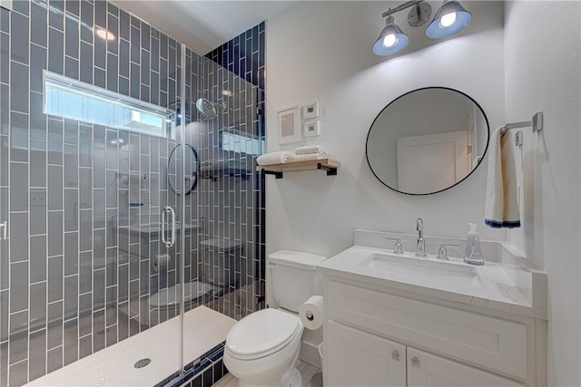 bathroom with vanity, a shower with shower door, and toilet