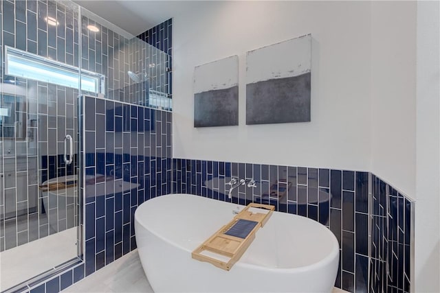 bathroom with separate shower and tub and tile walls