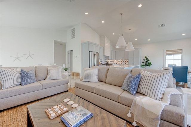 living room with hardwood / wood-style floors and high vaulted ceiling