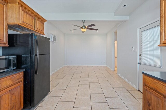 410 Knickerbocker St, Corpus Christi, TX 78418 - kitchen with freestanding refrigerator, ceiling fan, stainless steel microwave, brown cabinets, and dark countertops
