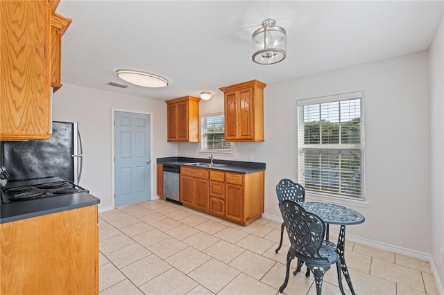 410 Knickerbocker St, Corpus Christi, TX 78418 - kitchen featuring dishwasher, a sink, dark countertops, freestanding refrigerator, and light tile patterned floors