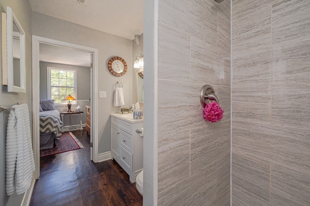 bathroom with a tile shower, vanity, and hardwood / wood-style flooring