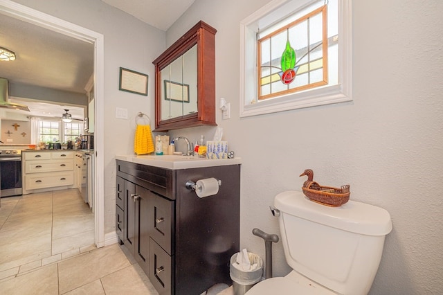 bathroom featuring tile patterned floors, ceiling fan, vanity, and toilet