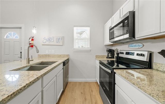 15101 Boca Grandi Dr, Corpus Christi, TX 78418 - kitchen featuring light wood finished floors, a sink, white cabinetry, and appliances with stainless steel finishes